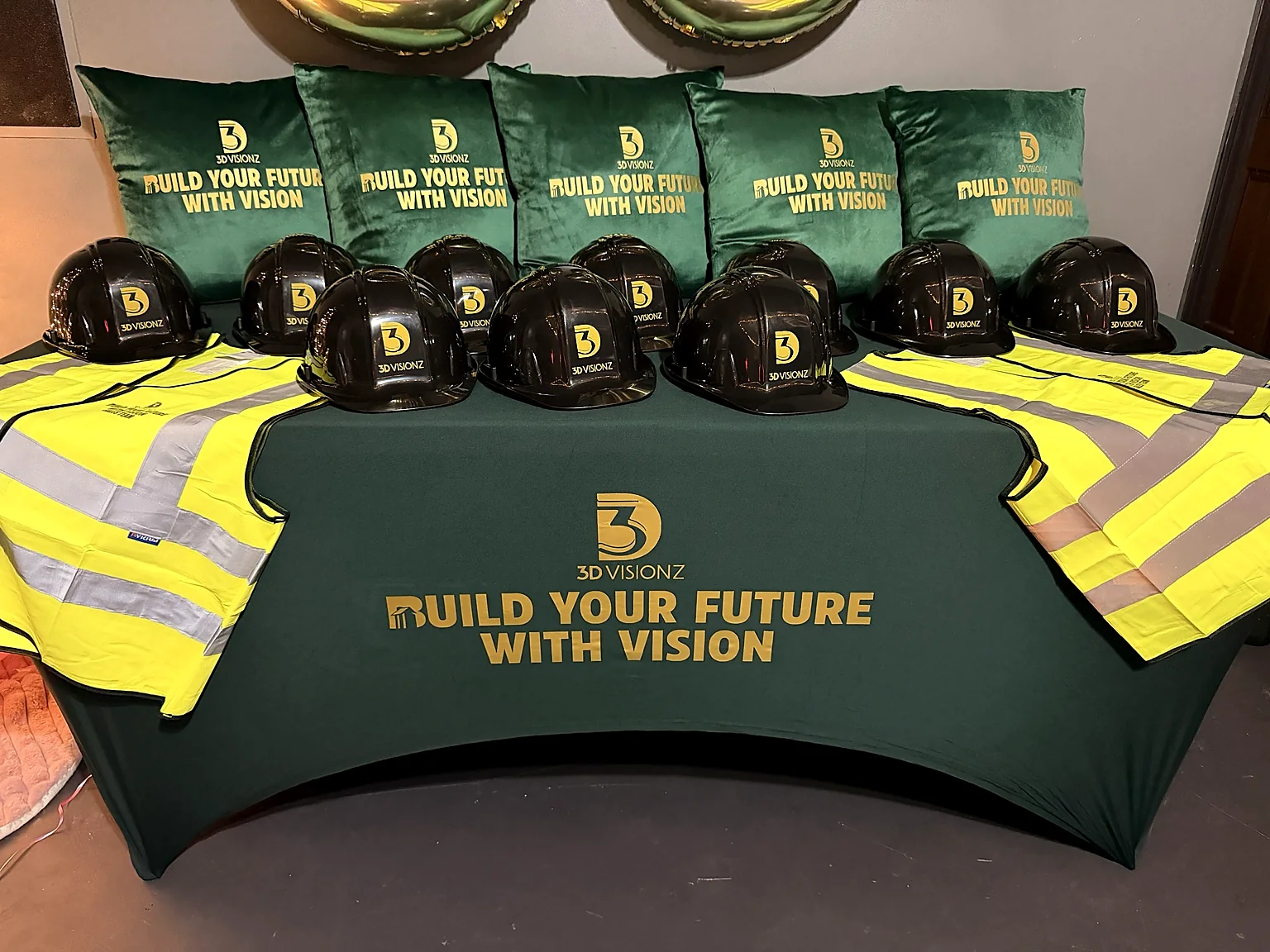 Branded construction hard hats, safety vests, pillows, and table display
