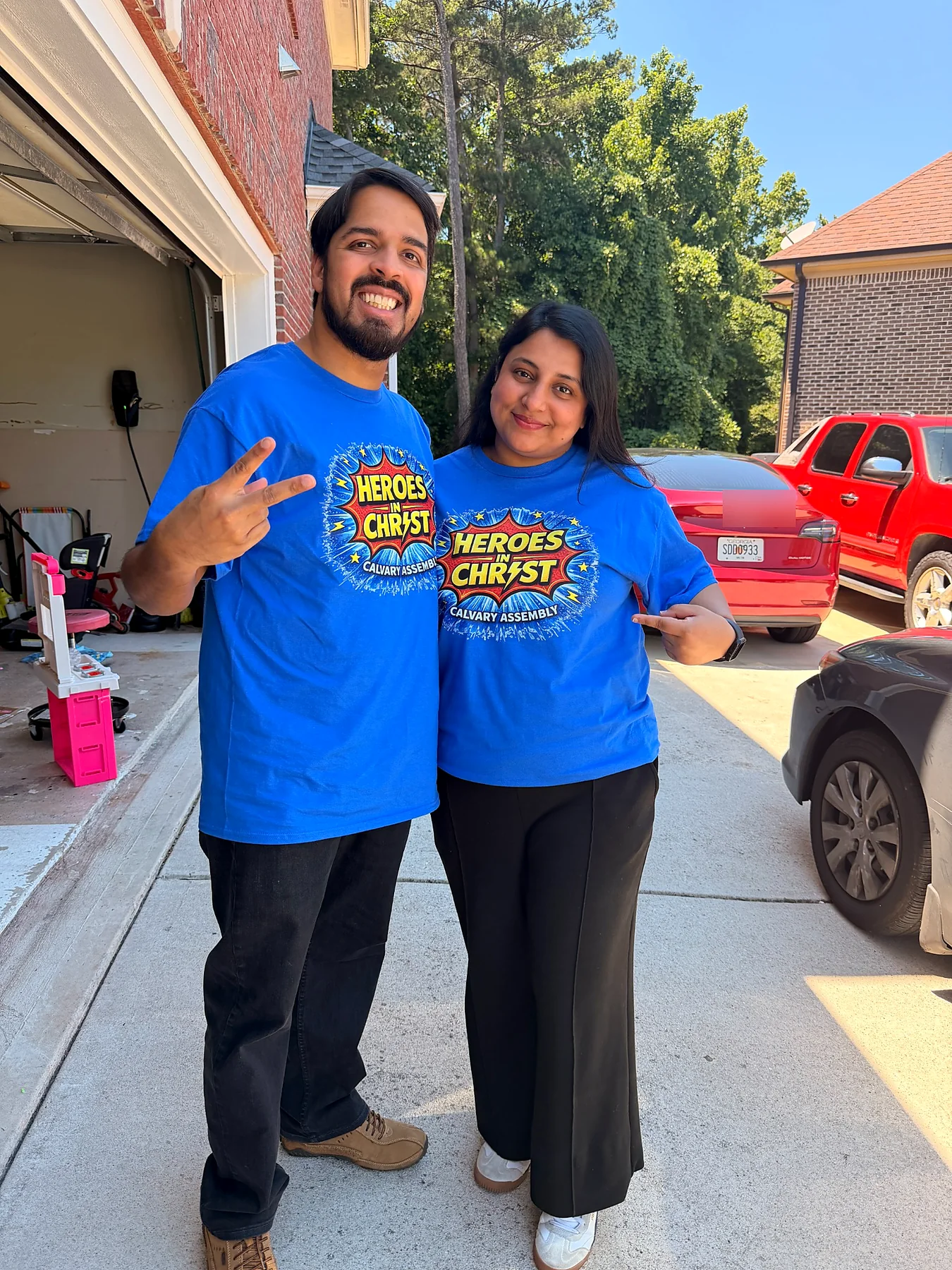 Two customers wearing matching blue Heroes in Christ shirts produced by Adequate Apparel