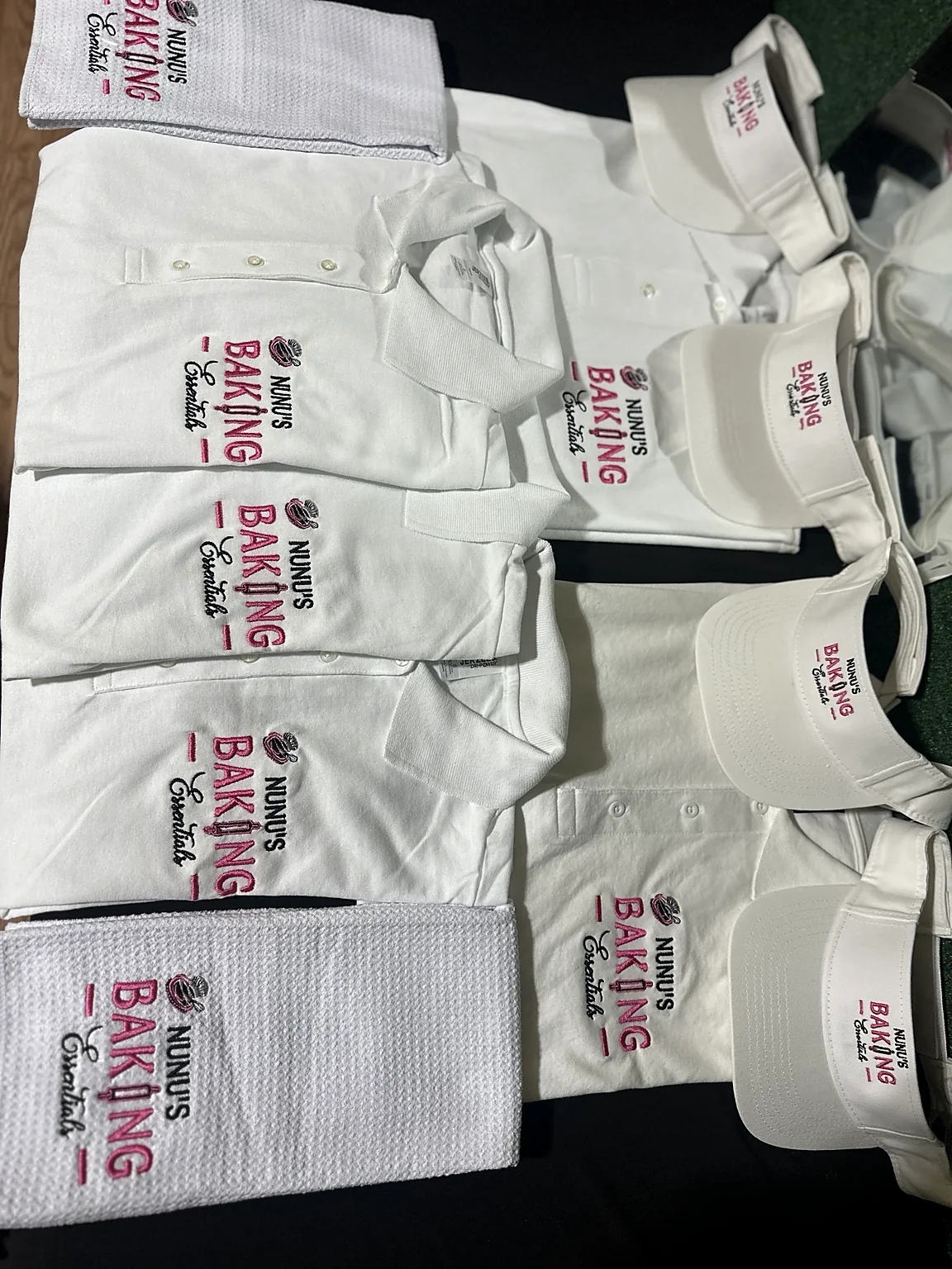 White embroidered baking polos, visors, and towels